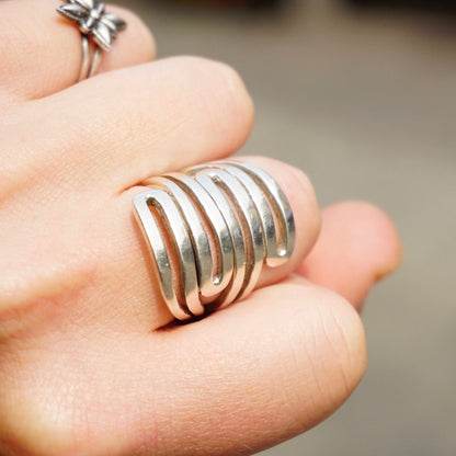 Vintage sterling silver spiral cut-out ring on finger, unique statement jewelry made in India, 925 silver ring closeup