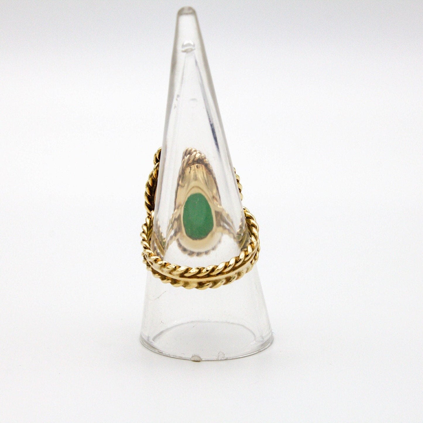 Vintage 14K gold cocktail ring with green jade center stone and diamond accent, featuring a twisted gold band design. Large jade stone set in a clear glass or plastic display cone.