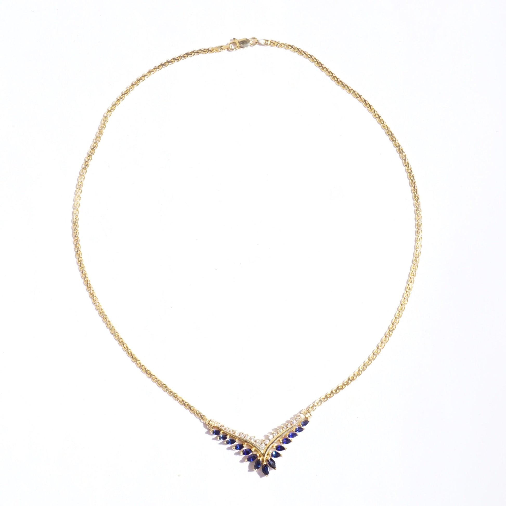 Vintage 14k gold sapphire and diamond choker necklace featuring an elegant V-shaped design with alternating deep blue sapphire and sparkling diamond stones on a delicate gold chain.