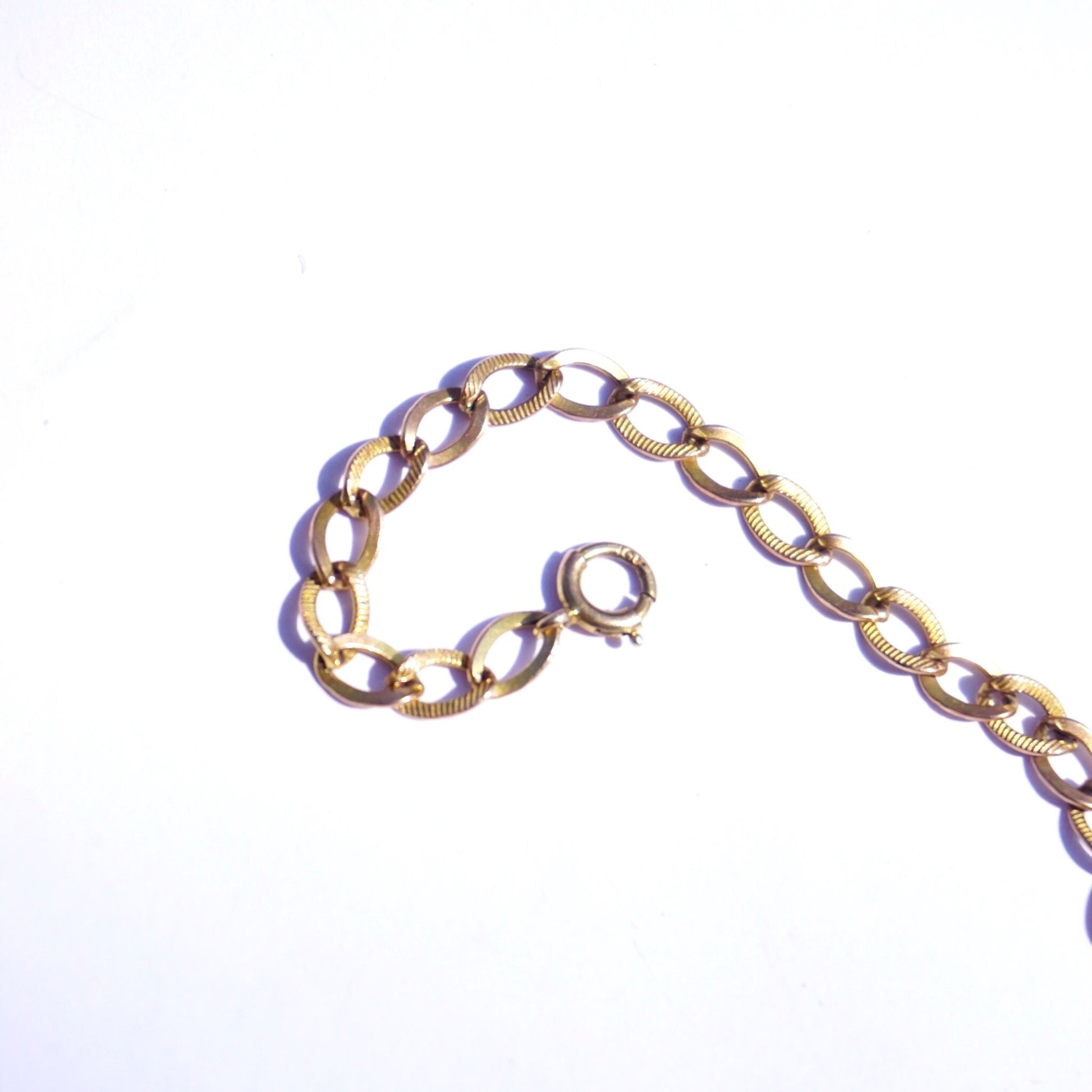 10K gold Cuban chain bracelet with delicate, minimalist links, measuring 7 inches long, in a vintage style perfect for everyday wear or special occasions.