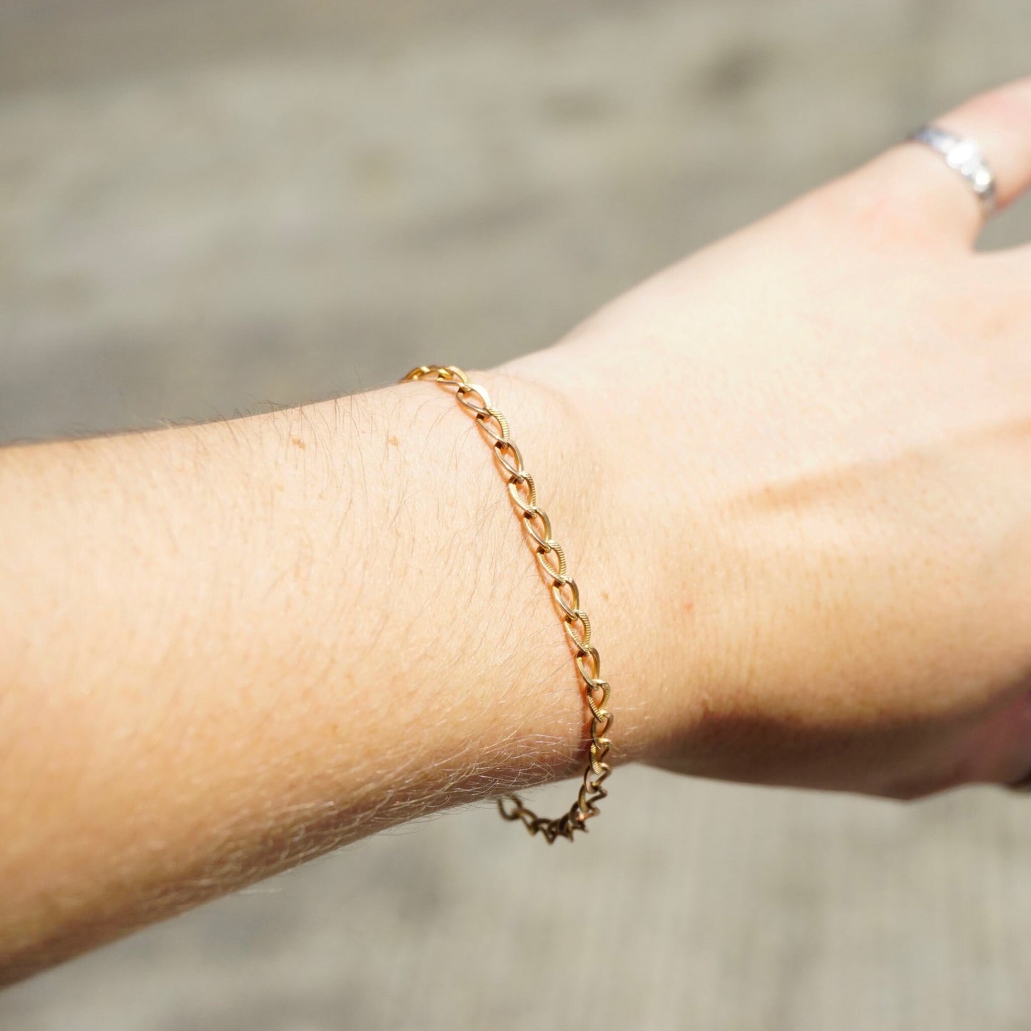 10K gold vintage Cuban chain bracelet on wrist, delicate minimalist gold chain bracelet, 7 inch length Cuban link bracelet close-up