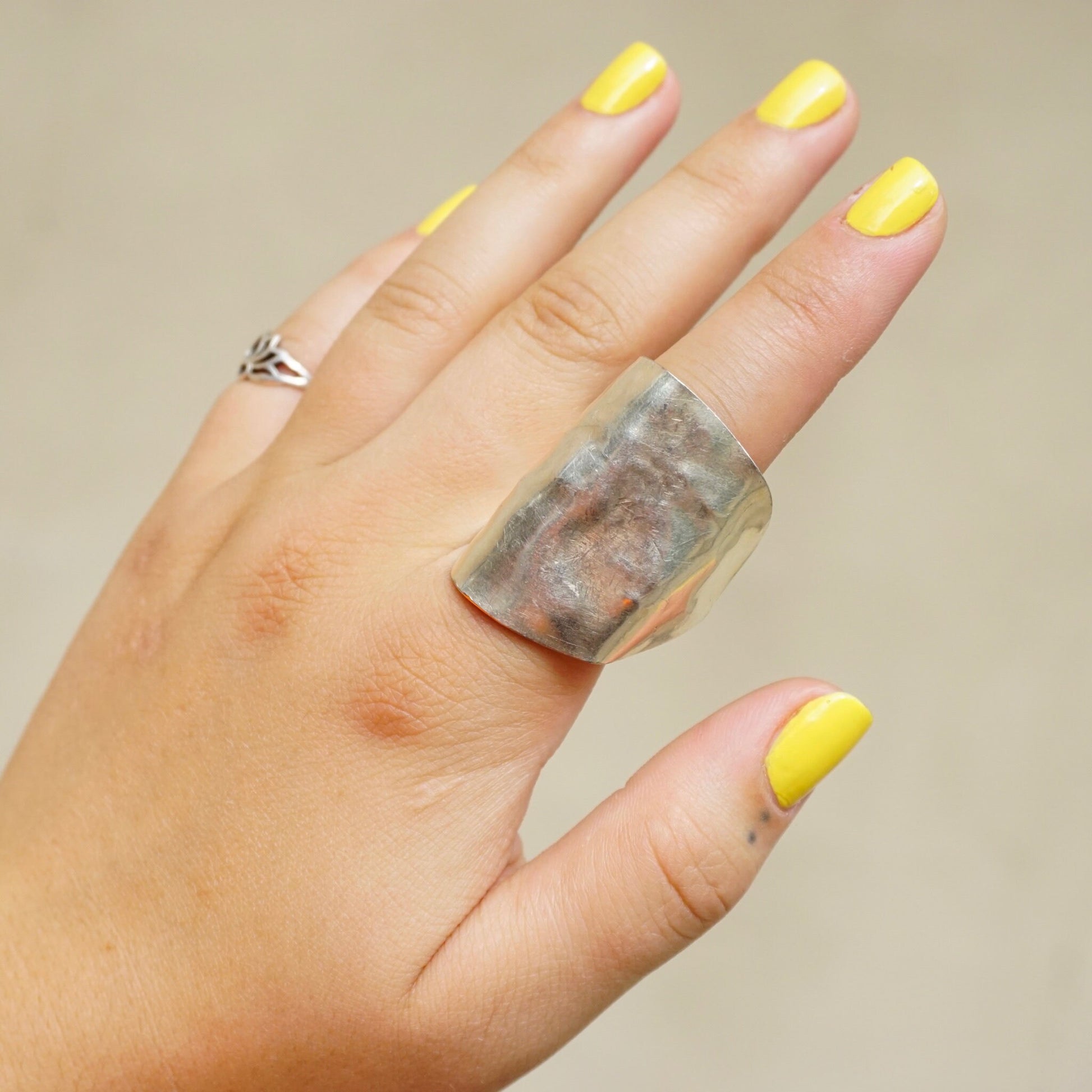 Alt text: Yellow manicured nails display a vintage sterling silver spoon ring with a unique bent design, sized as a US 8 statement ring.