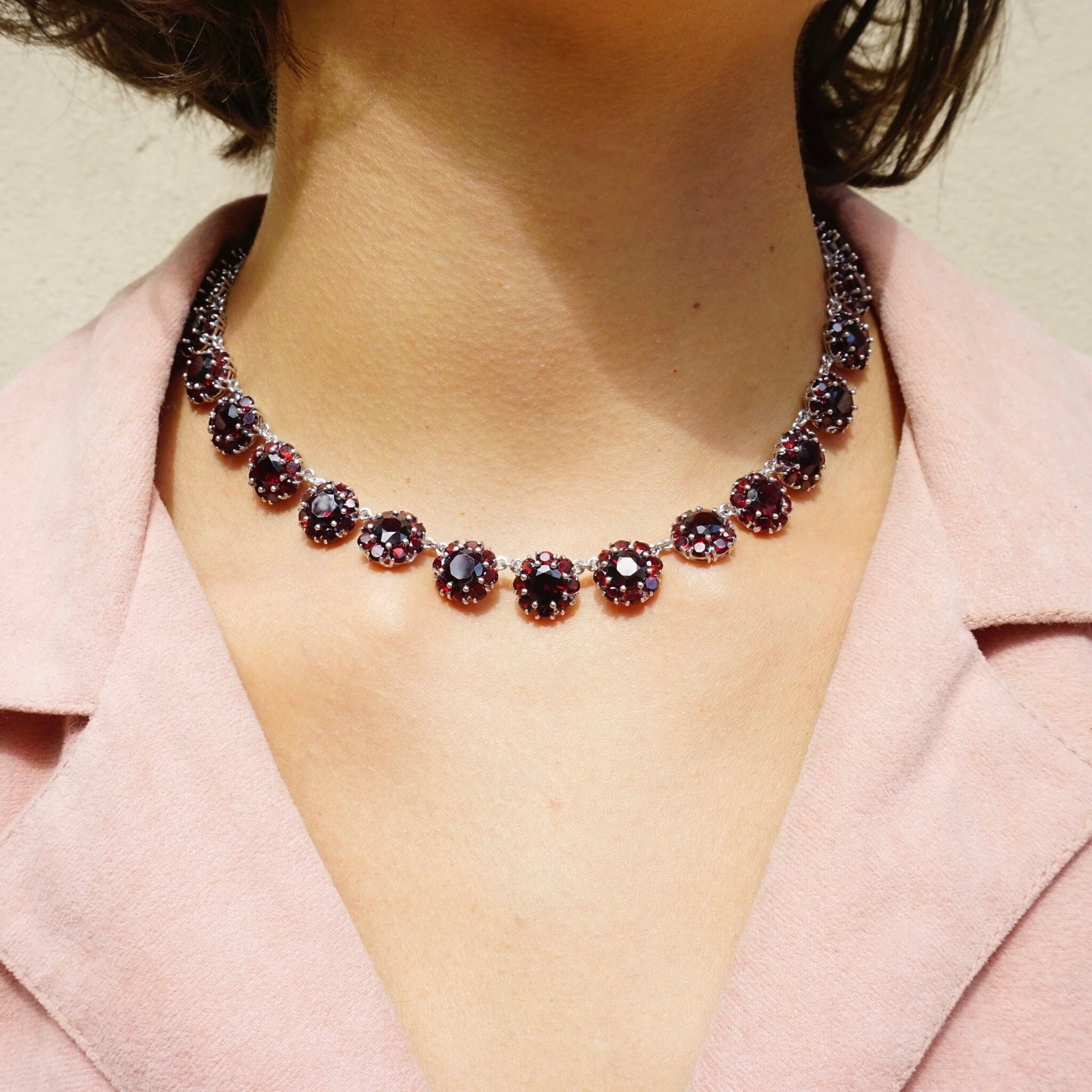 Vintage Sterling Silver Garnet Glass Stone Choker Necklace worn by a woman, featuring beautiful deep red stones set in an ornate silver collar design.