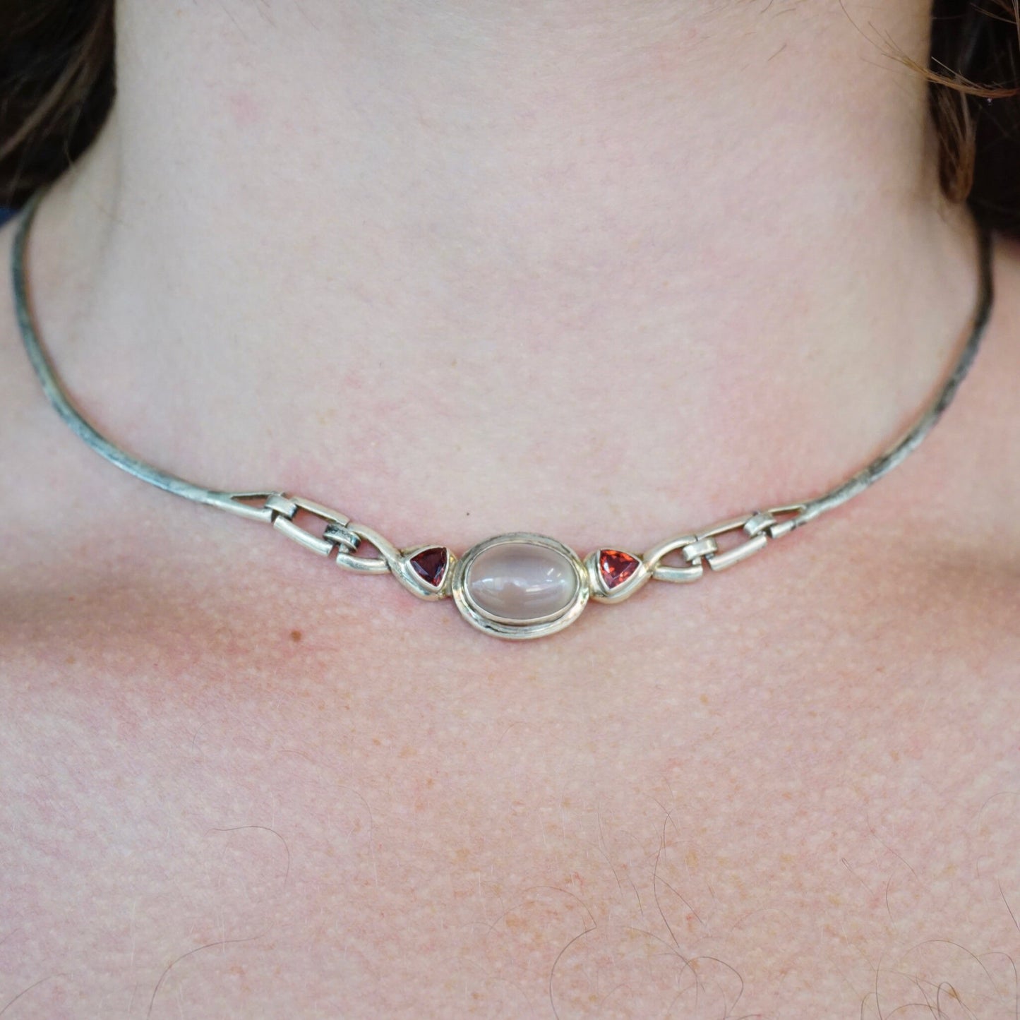 Vintage sterling silver moonstone choker necklace with red jewel accents on pale skin, unique 925 silver jewelry.