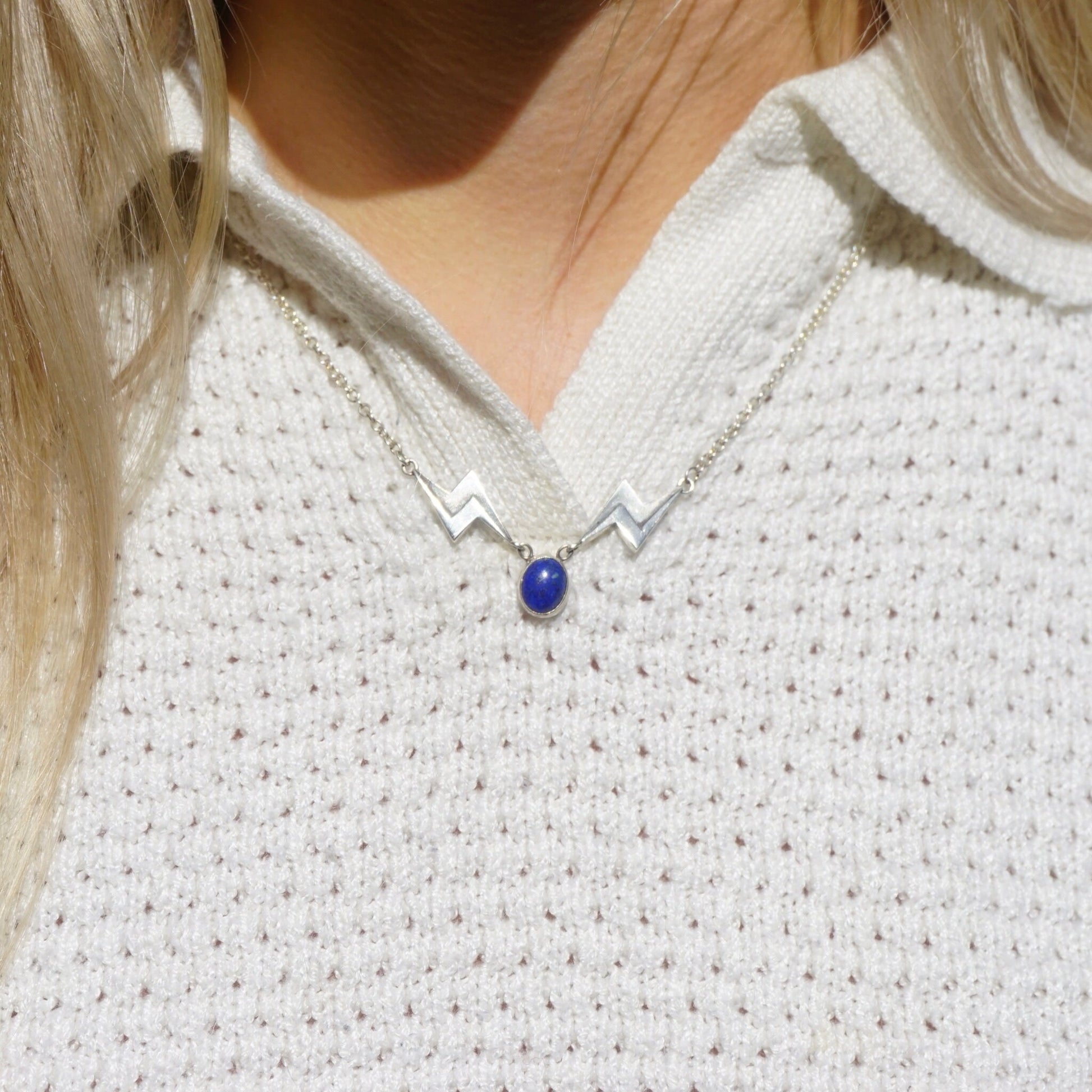 Vintage lapis lazuli silver necklace featuring a unique lightning bolt pendant on a silver chain, showcasing the deep blue lapis stone against the elegant silver design for a striking and eye-catching piece of jewelry.