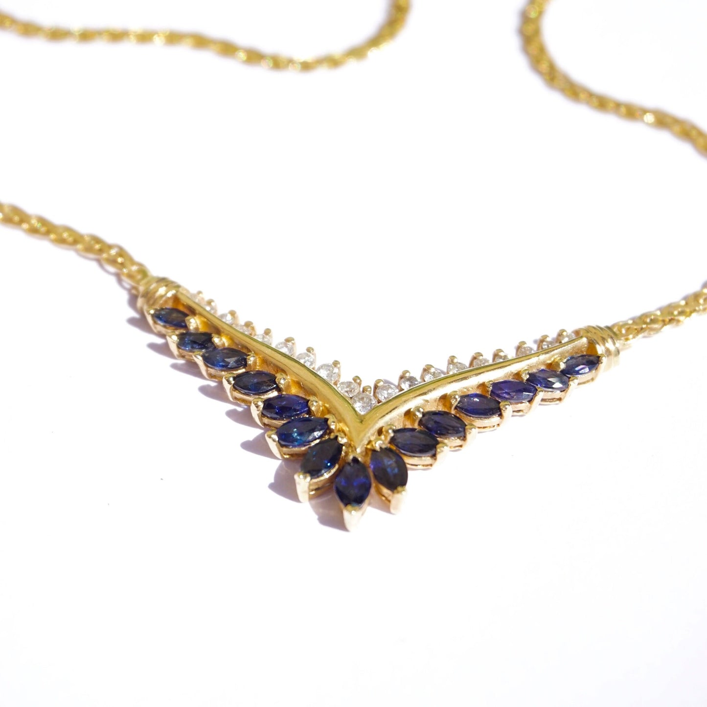 Vintage 14k gold choker necklace with sapphire and diamond accents, featuring an elegant V-shaped design set with deep blue sapphire stones bordered by sparkling diamonds on a delicate gold chain.