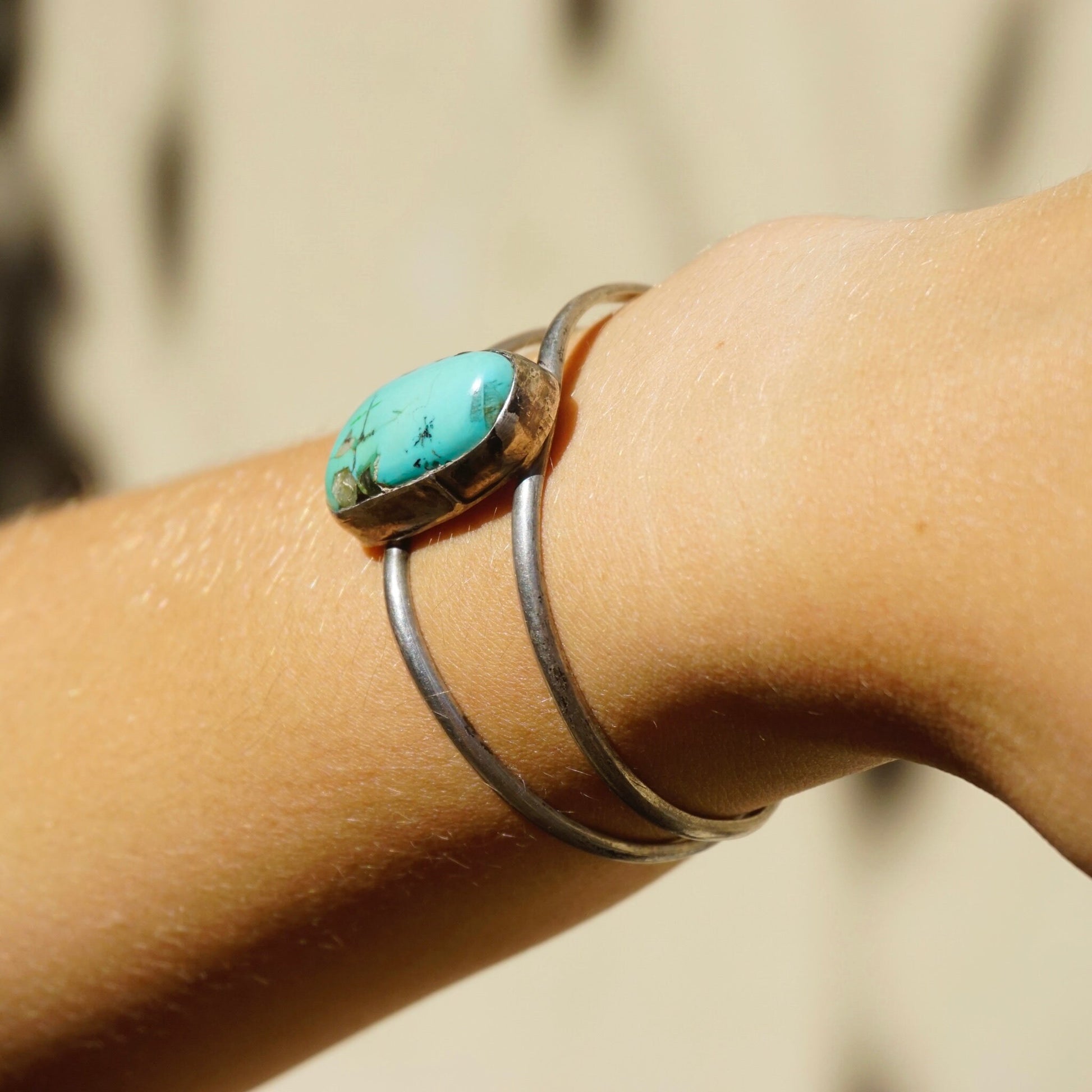 Vintage silver cuff bracelet with oval turquoise stone on wrist