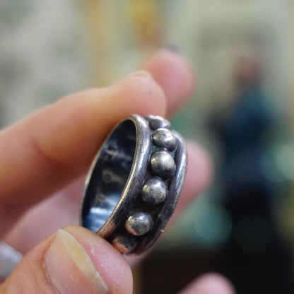 Vintage hammered sterling silver ring with round ball details held between fingers, showing tarnished patina on the 925 Mexico silver men's ring.