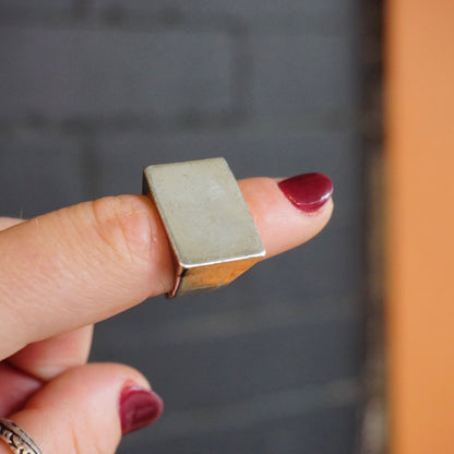 Vintage sterling silver signet ring held between fingers, showing thick rectangular silver face suitable for engraving. Classic, solid 925 silver jewelry ring, ideal as a men's silver ring or unisex design.