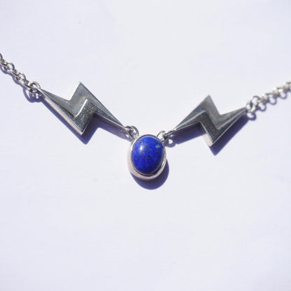 Vintage lapis lazuli silver necklace featuring a unique lightning bolt pendant on a delicate silver chain, showcasing the stunning deep blue color of the lapis stone against the polished silver setting.