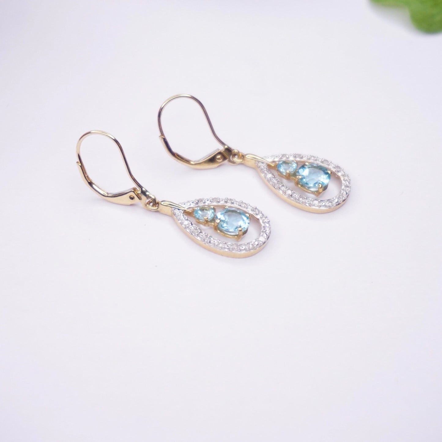 Vintage 14K gold teardrop earrings featuring aquamarine gemstones accented with diamonds, creating an elegant and timeless look with light blue stones set in gold.