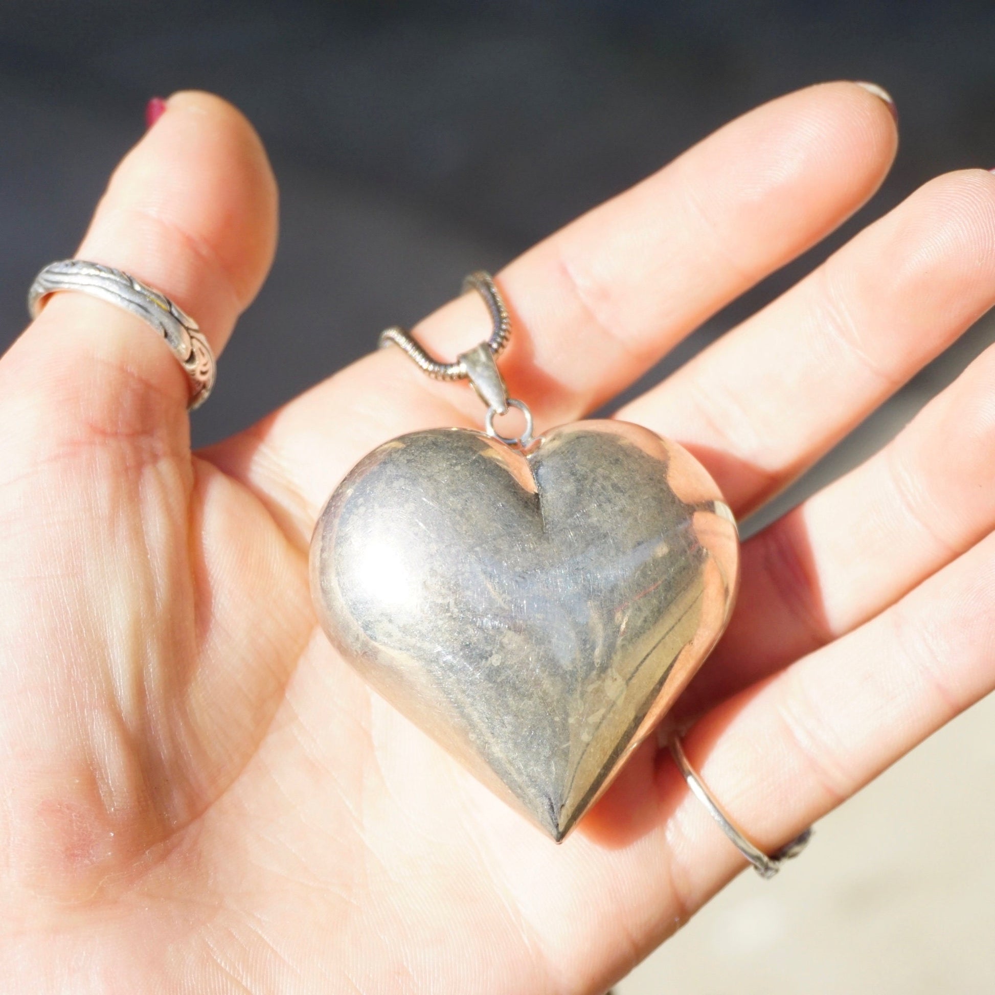 Vintage silver large heart pendant necklace on hand, 925 sterling silver rope chain, statement jewelry piece close-up