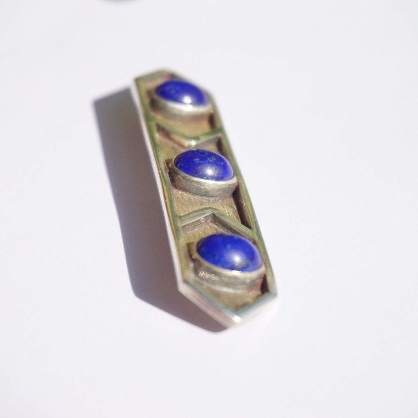 Vintage lapis lazuli and sterling silver brooch with three round cabochon lapis stones set in a minimalist rectangular silver design.