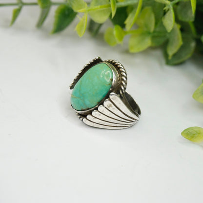 Vintage turquoise and sterling silver ring featuring a natural turquoise stone set in an ornate silver wing design, handcrafted Native American 925 silver jewelry.