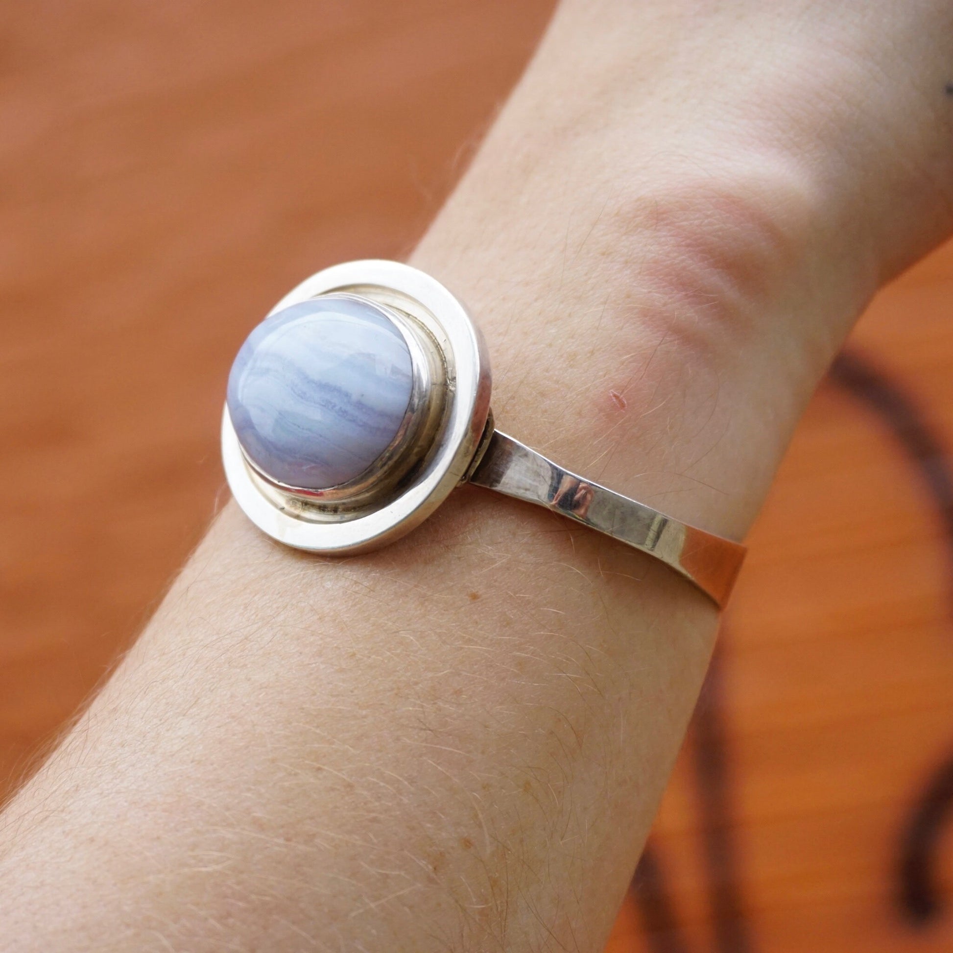 Vintage sterling silver bracelet with raised blue lace agate stone on a wrist