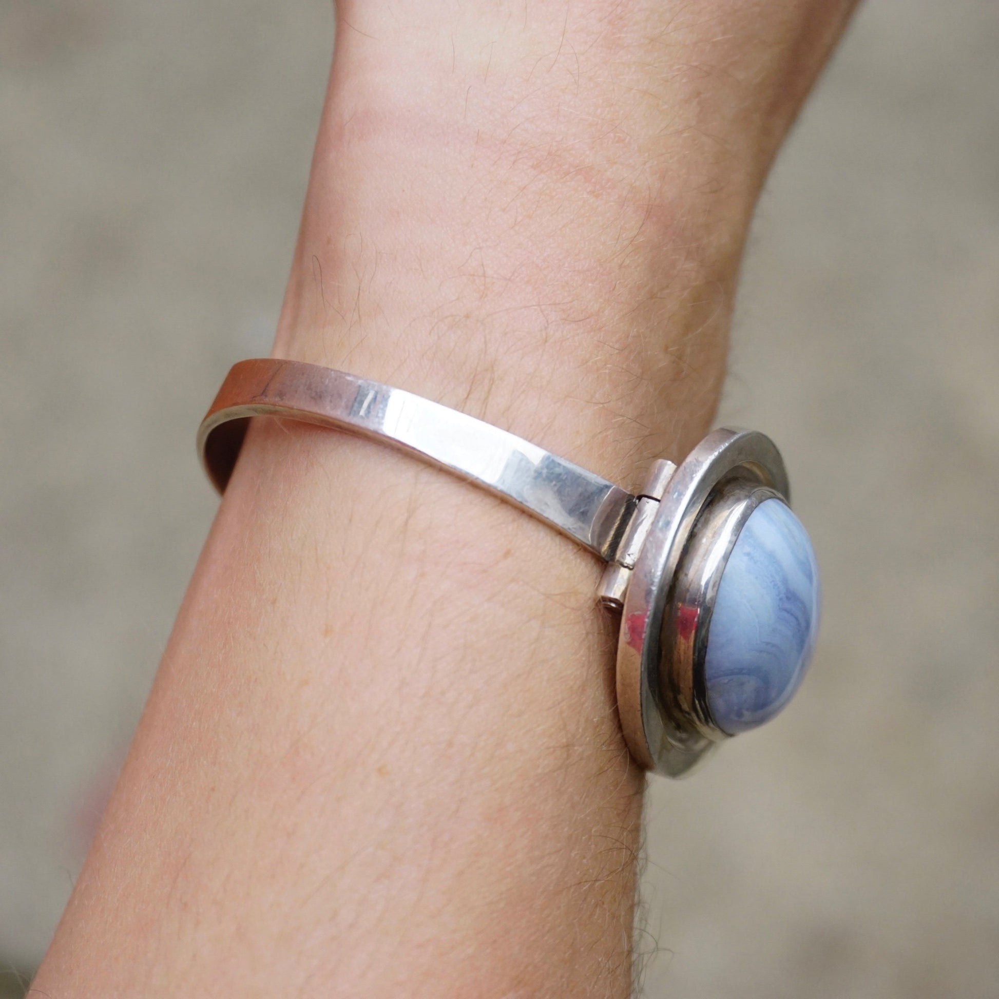 Vintage blue lace agate sterling silver bracelet on wrist, featuring a raised blue stone centerpiece. Handcrafted 925 silver jewelry by Leenhardt Geneve.