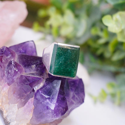 Vintage sterling silver ring with square green druzy quartz stone set atop amethyst crystals, stamped Mex925, on white background with greenery