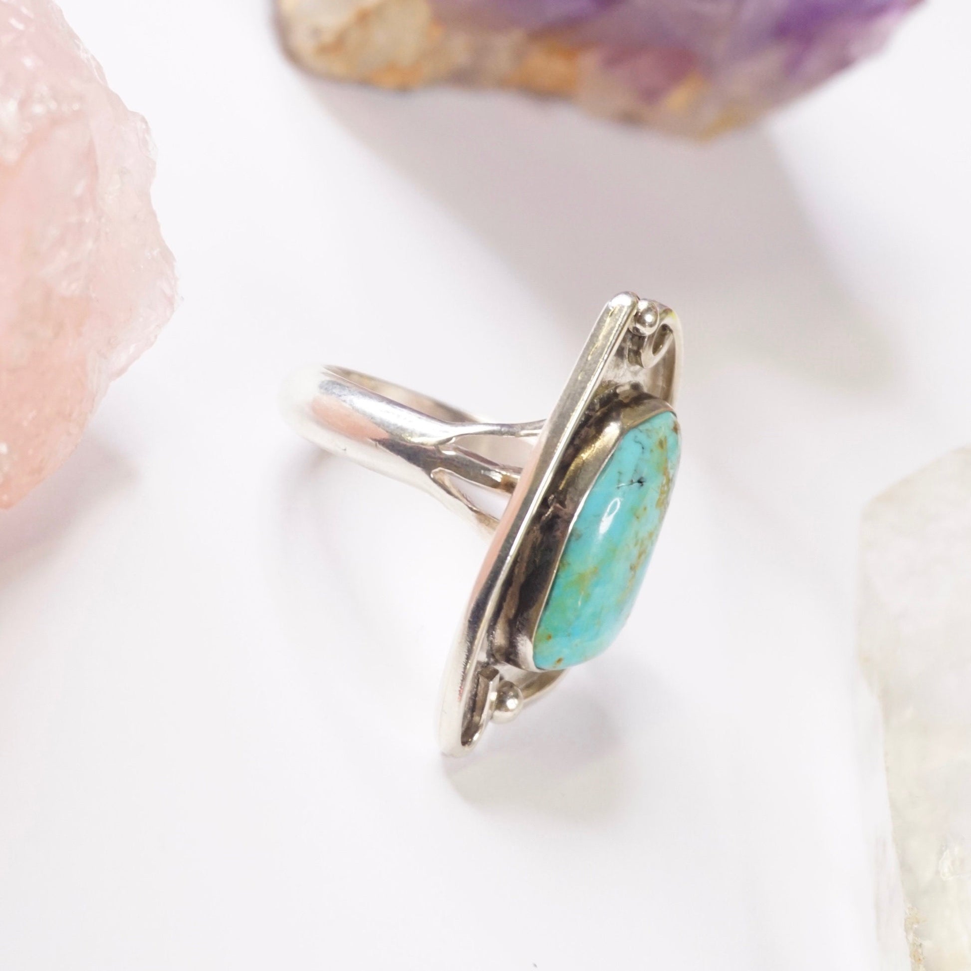 Vintage turquoise sterling silver ring featuring a large natural turquoise stone in an ornate silver setting, showcasing Native American jewelry craftsmanship.