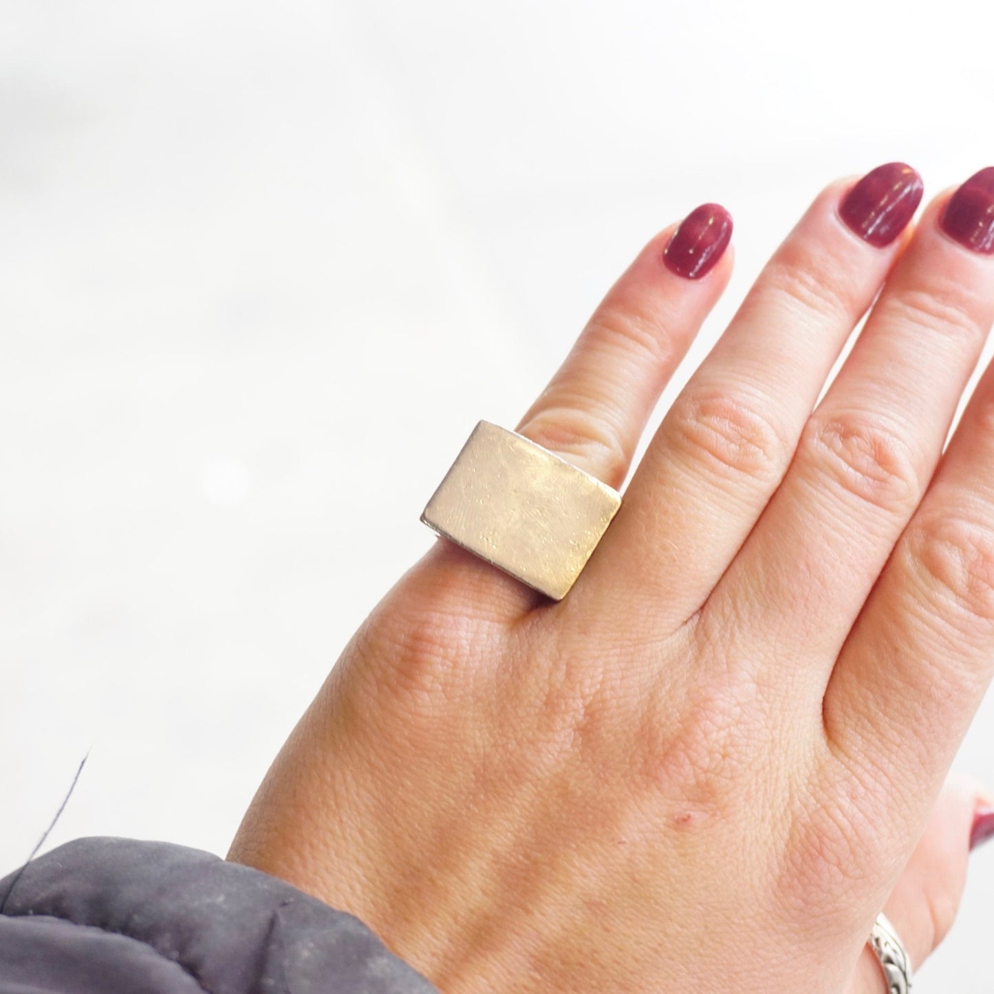 Vintage sterling silver rectangular signet ring on a hand with maroon nail polish, thick solid 925 silver ring with large flat face, men's silver statement ring jewelry