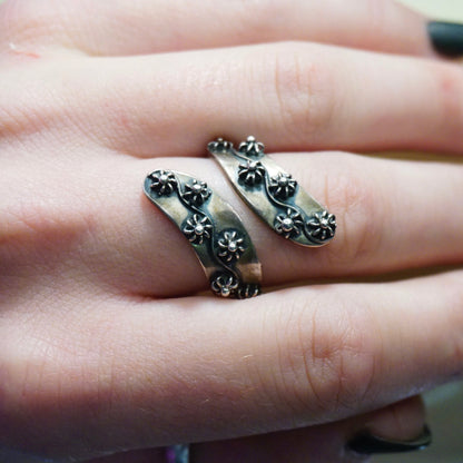 Vintage sterling silver wrap around ring featuring beaded flower details, made in Taxco, Mexico. The ring is shown on a person's hand.