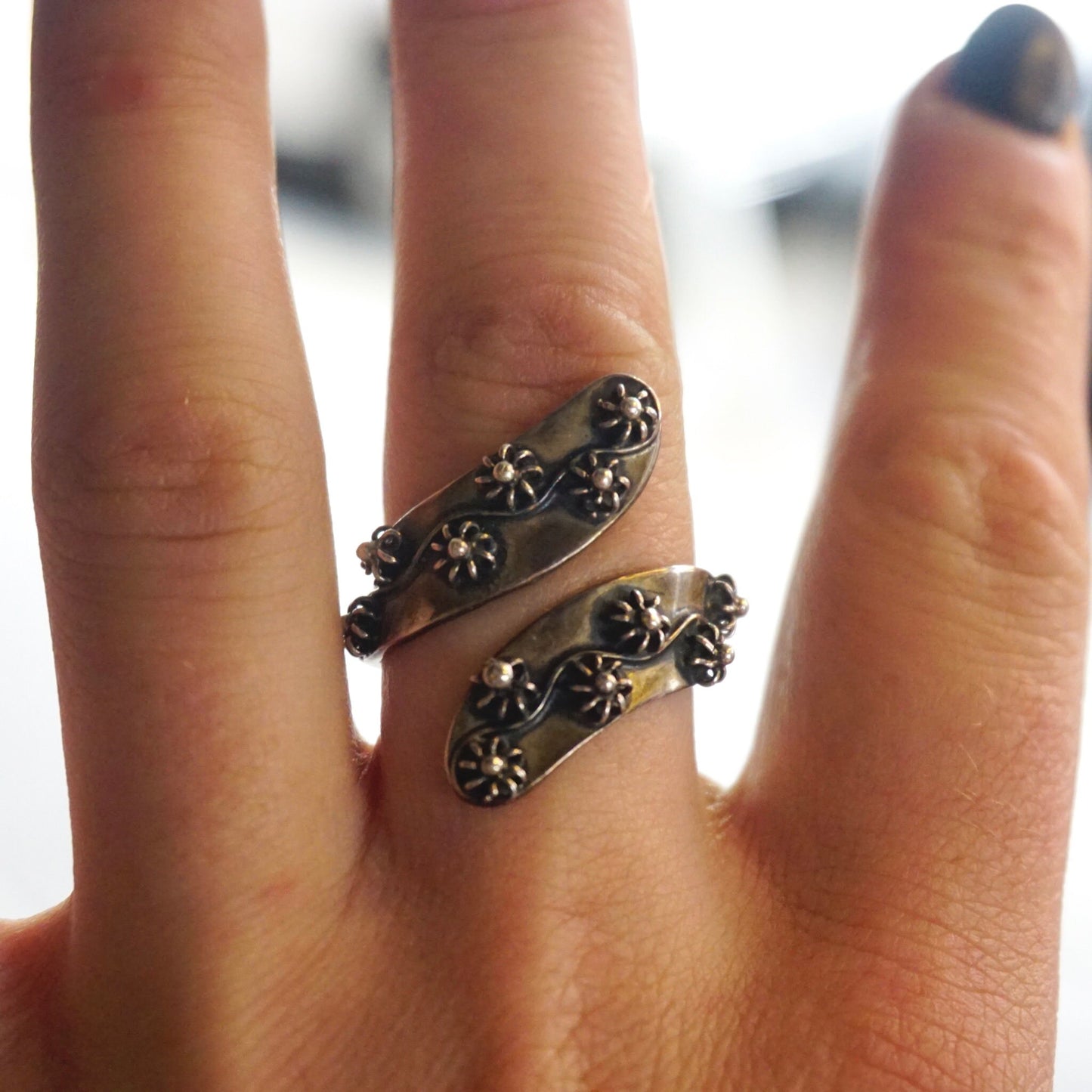 Vintage sterling silver beaded flower twist wrap around ring with floral details, made in Taxco, Mexico 925 silver, shown on a hand modeling the unique design.