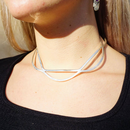 Sterling silver cut out collar choker necklace from Mexico on woman's neck against black shirt