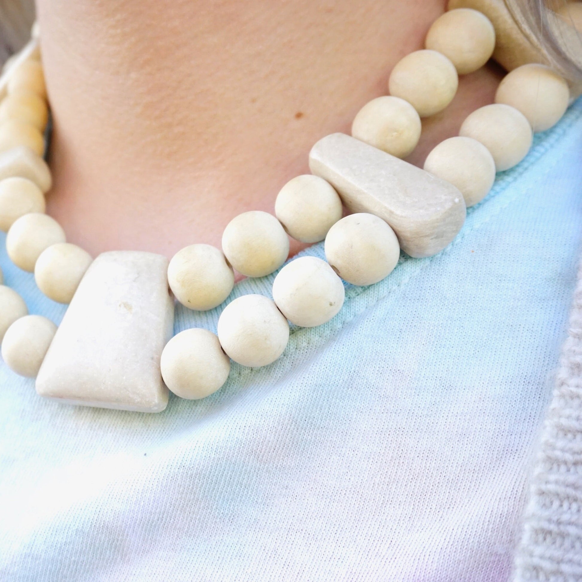 Vintage Gerda Lynggaard Monies two-strand chunky wooden bead necklace with asymmetrical white stone accents, worn as a collar-style statement piece from the mid-century era.