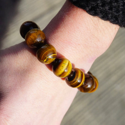 Vintage tiger's eye beaded stretch bracelet on wrist, featuring large, glossy golden brown tiger's eye beads.