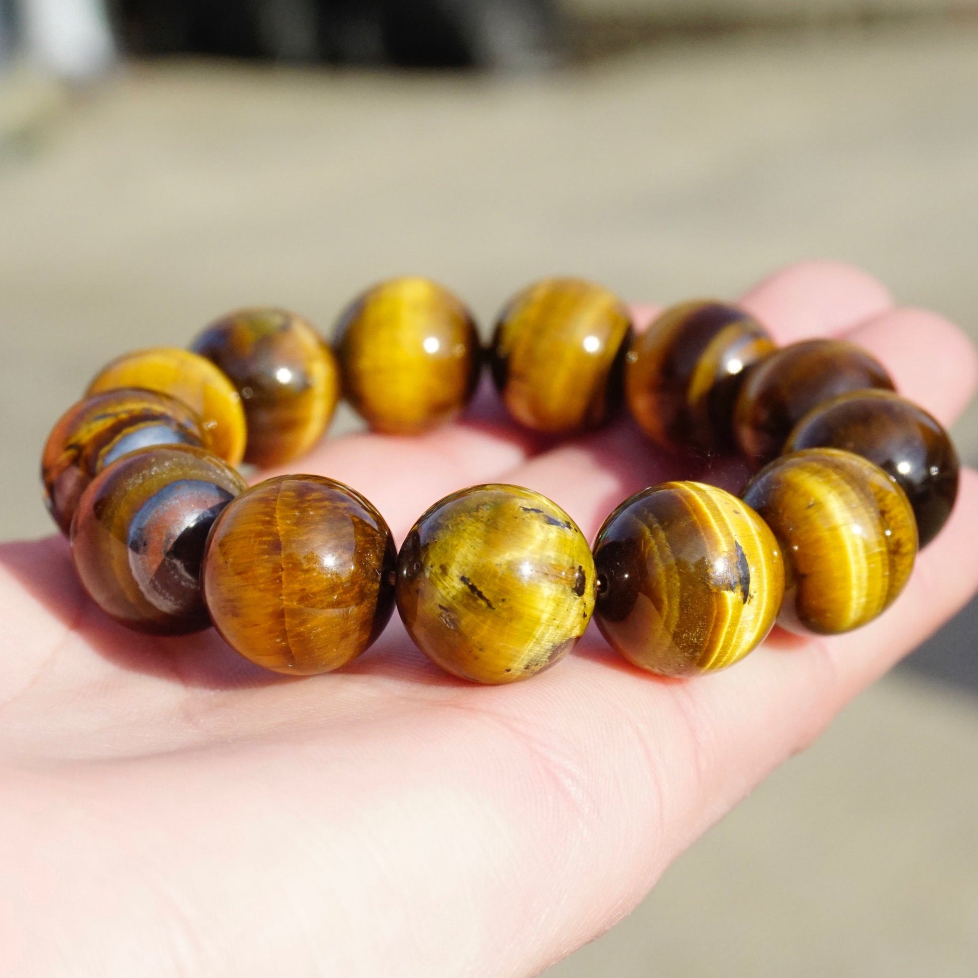 Vintage tigers eye beaded stretch bracelet with large, golden brown beads on a pink fabric surface.