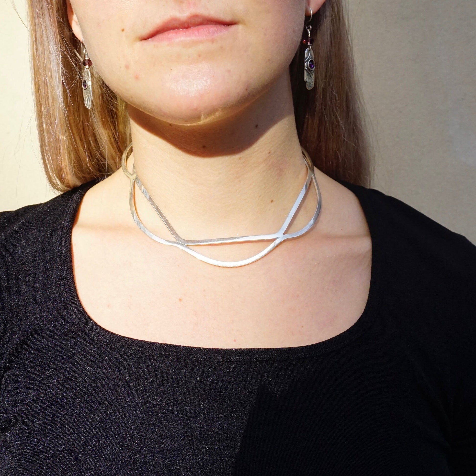 Vintage sterling silver cut out collar necklace from Mexico on a model's neck, featuring a wavy, minimalist modern design. The 925 silver choker sits at the base of the neck.