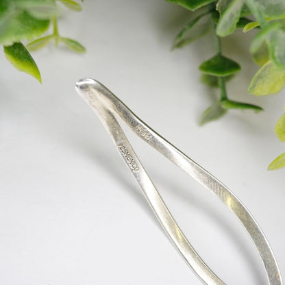 Vintage sterling silver cut out collar necklace from Mexico, featuring a wavy, minimalist design. 925 silver choker necklace with modern aesthetic, photographed on white background with greenery.