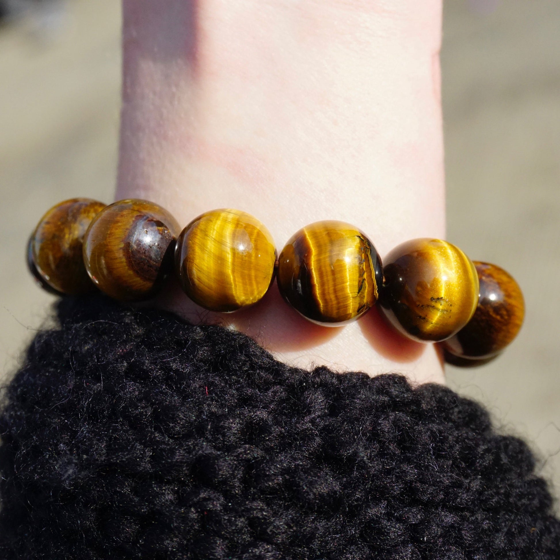 Brown and golden tiger's eye beaded stretch bracelet on a dark textured surface