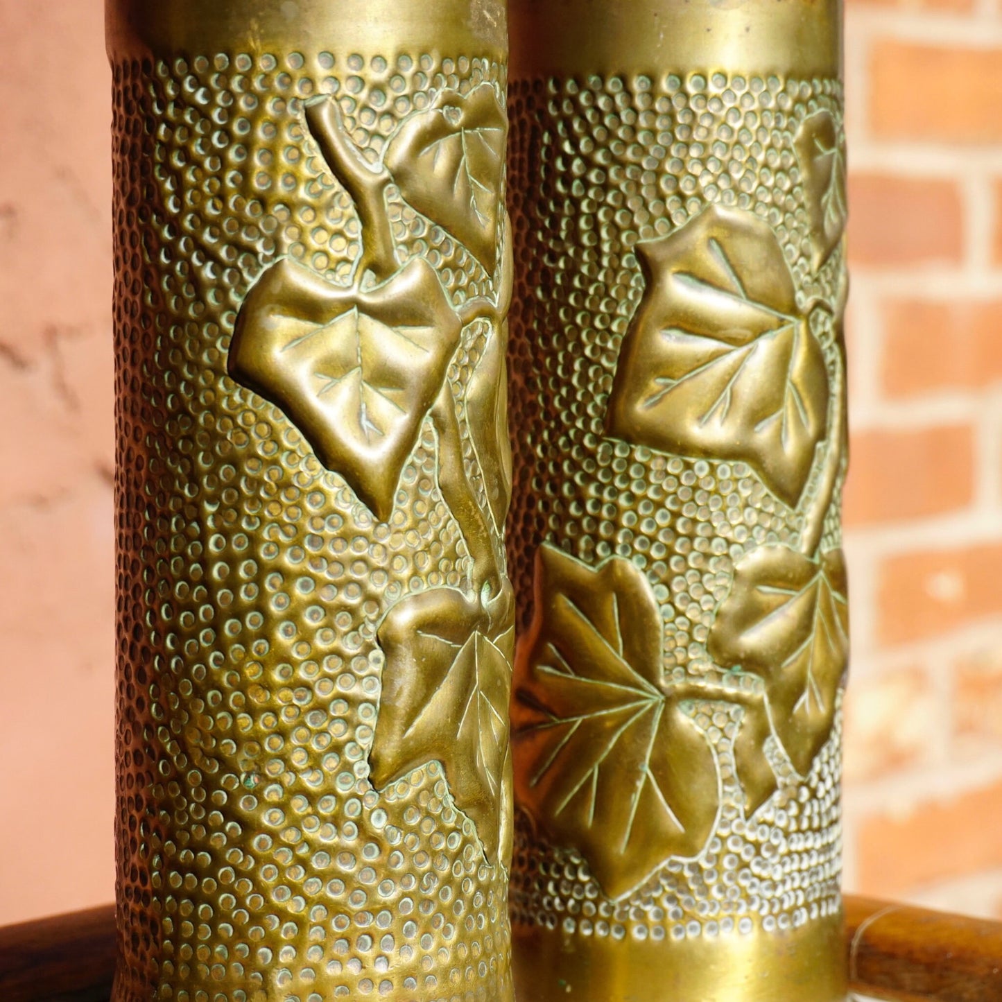 Antique brass shell casing from 1917 etched with intricate leaf design, repurposed as decorative brush holder or vase, example of World War I trench art