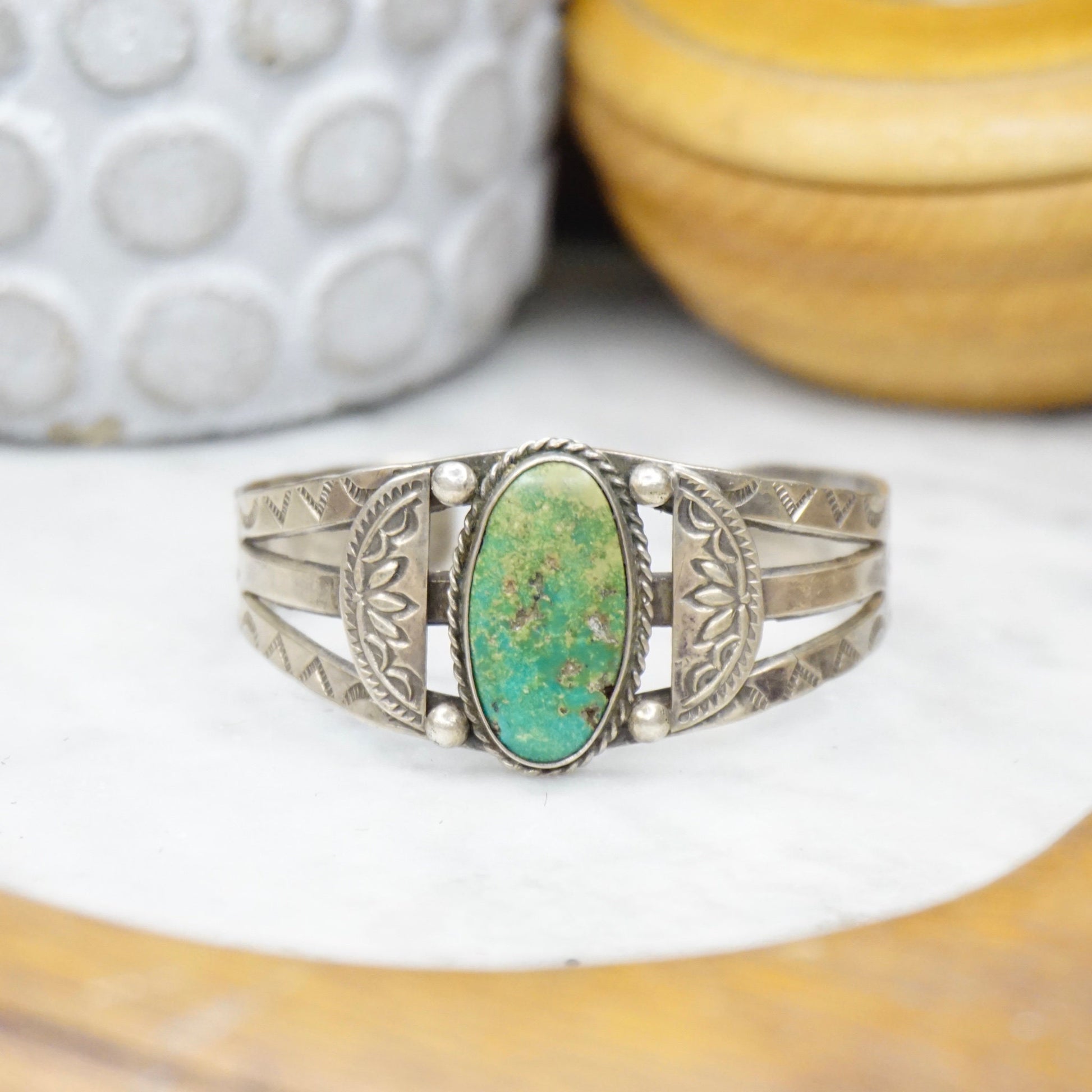 Vintage Native American coin silver cuff bracelet with natural turquoise stone, featuring intricate handmade design. Old pawn jewelry piece showcasing detailed silver work.