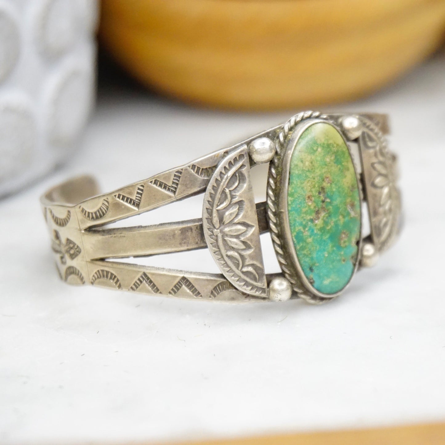 Vintage Native American sterling silver cuff bracelet featuring a natural turquoise stone set in an intricately stamped silver design, handcrafted old pawn jewelry.