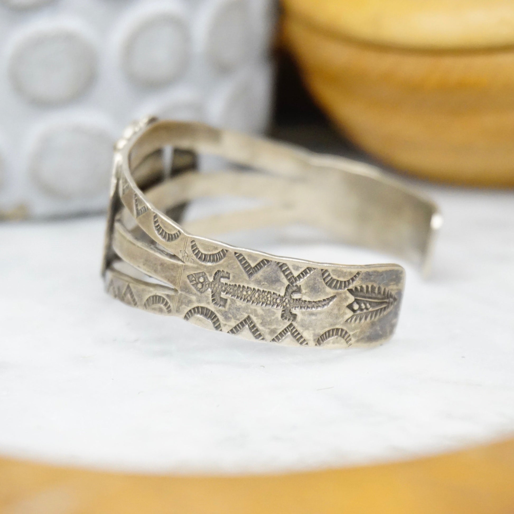 Vintage Native American coin silver cuff bracelet with intricate engraved design and natural turquoise accent, handcrafted old pawn jewelry.