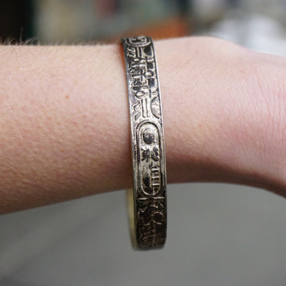 Vintage TAXCO Sterling Silver Hieroglyphic Bangle Bracelet with Egyptian motifs, worn on wrist, Made in Mexico 925 silver jewelry.