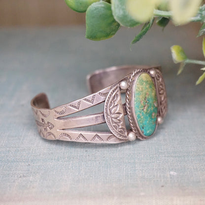 Vintage Native American silver cuff bracelet with intricate engraved designs and natural turquoise stone, handcrafted old pawn jewelry