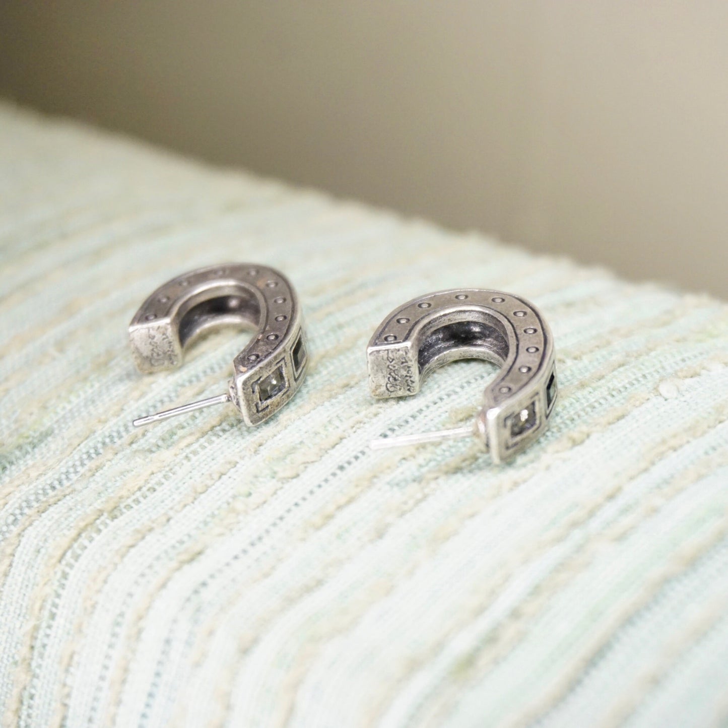 Vintage Patricia Lock silver plated half moon stud earrings with black and white crystals on white knit fabric