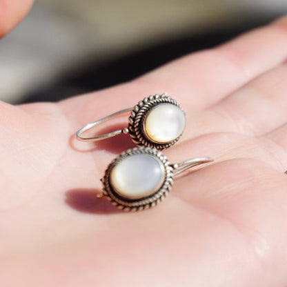 Vintage silver moonstone drop earrings on open palm