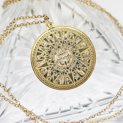 24KT gold electroplated sterling silver Mayan sun calendar pendant necklace with intricate Aztec sun god medallion design on double-sided pendant, suspended from a 24-inch cable chain, on white fabric background.