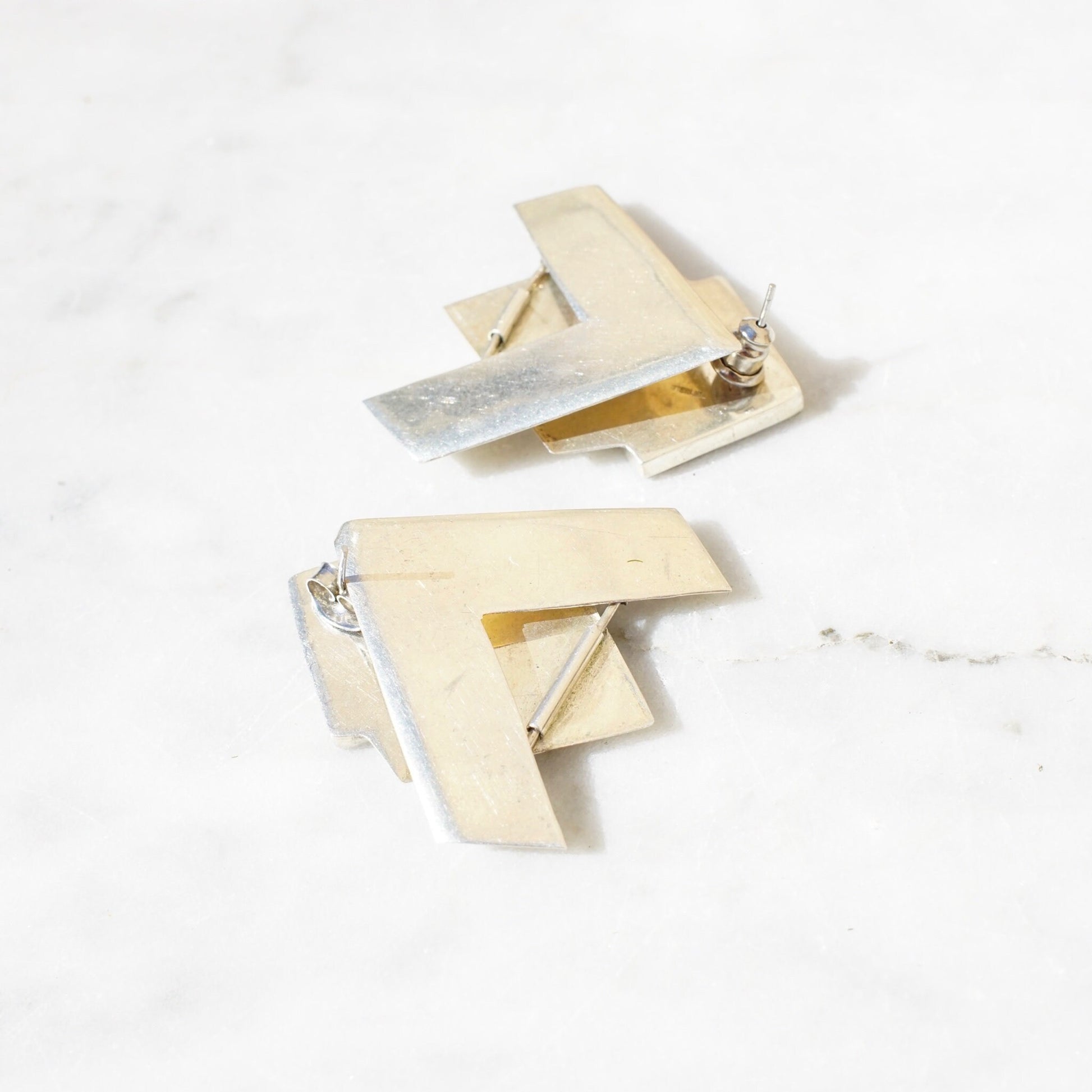 Vintage sterling silver geometric stud earrings with inlaid glass or stone, featuring a unique hinged checker design that allows the earrings to dangle. Modernist style 925 silver post earrings.