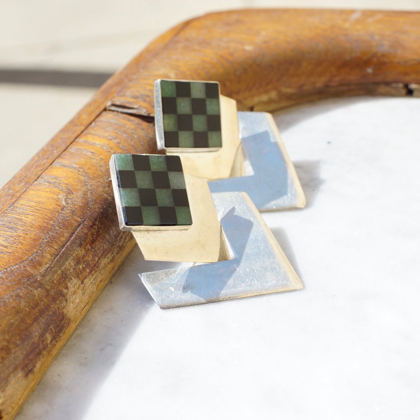 Vintage sterling silver hinged checker square earrings with inlaid green and light blue glass or stone, modernist dangle post earrings, unique 925 silver jewelry displayed on wooden surface.