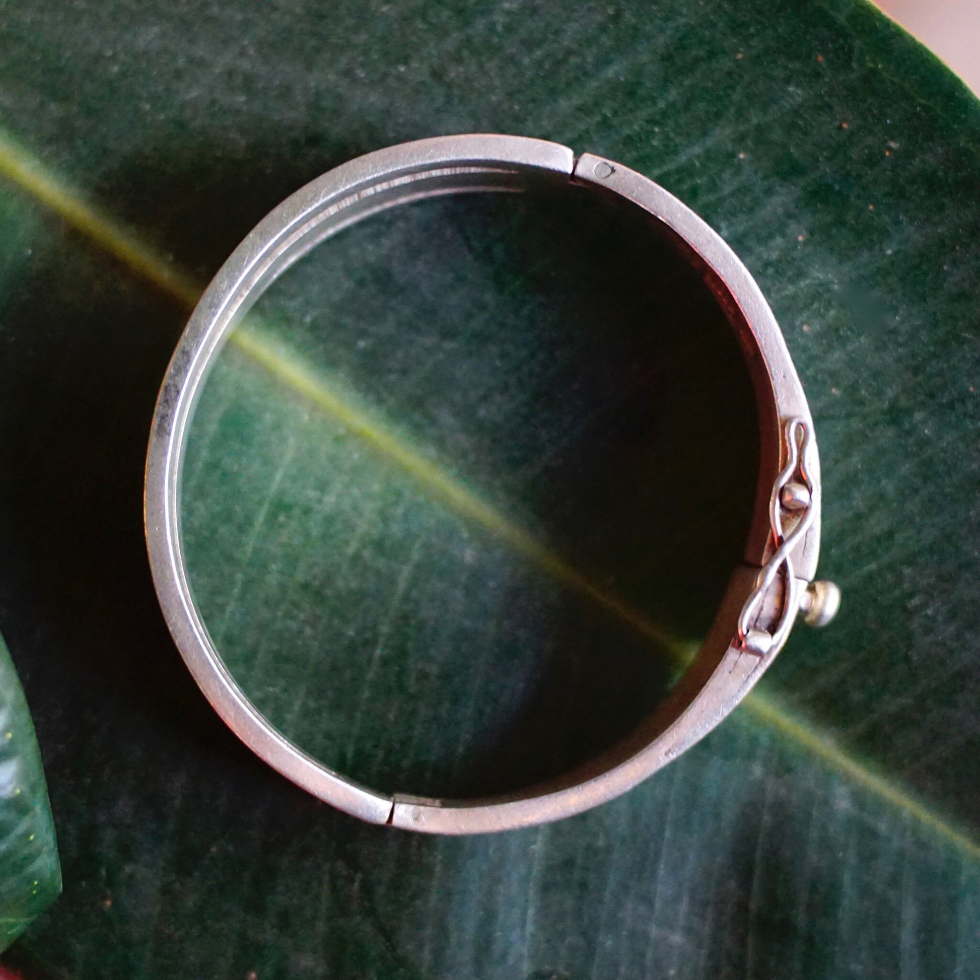 Vintage sterling silver hinged bangle bracelet from Taxco, Mexico with modernist cut out design, 6 1/2 inches long, 925 silver purity mark.