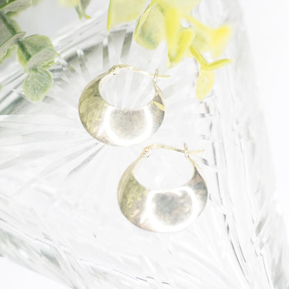 Vintage sterling silver half moon hoop earrings on white fur background with yellow flowers