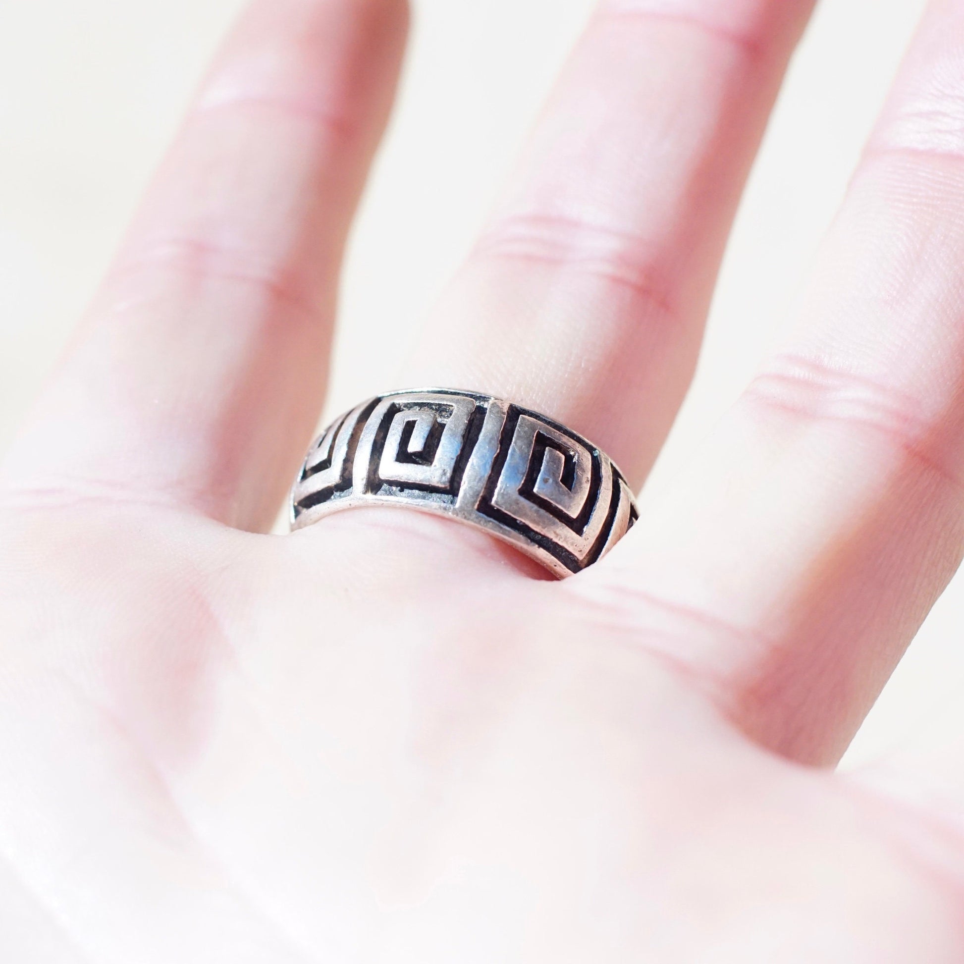 Vintage sterling silver square swirl Greek key band ring on a finger