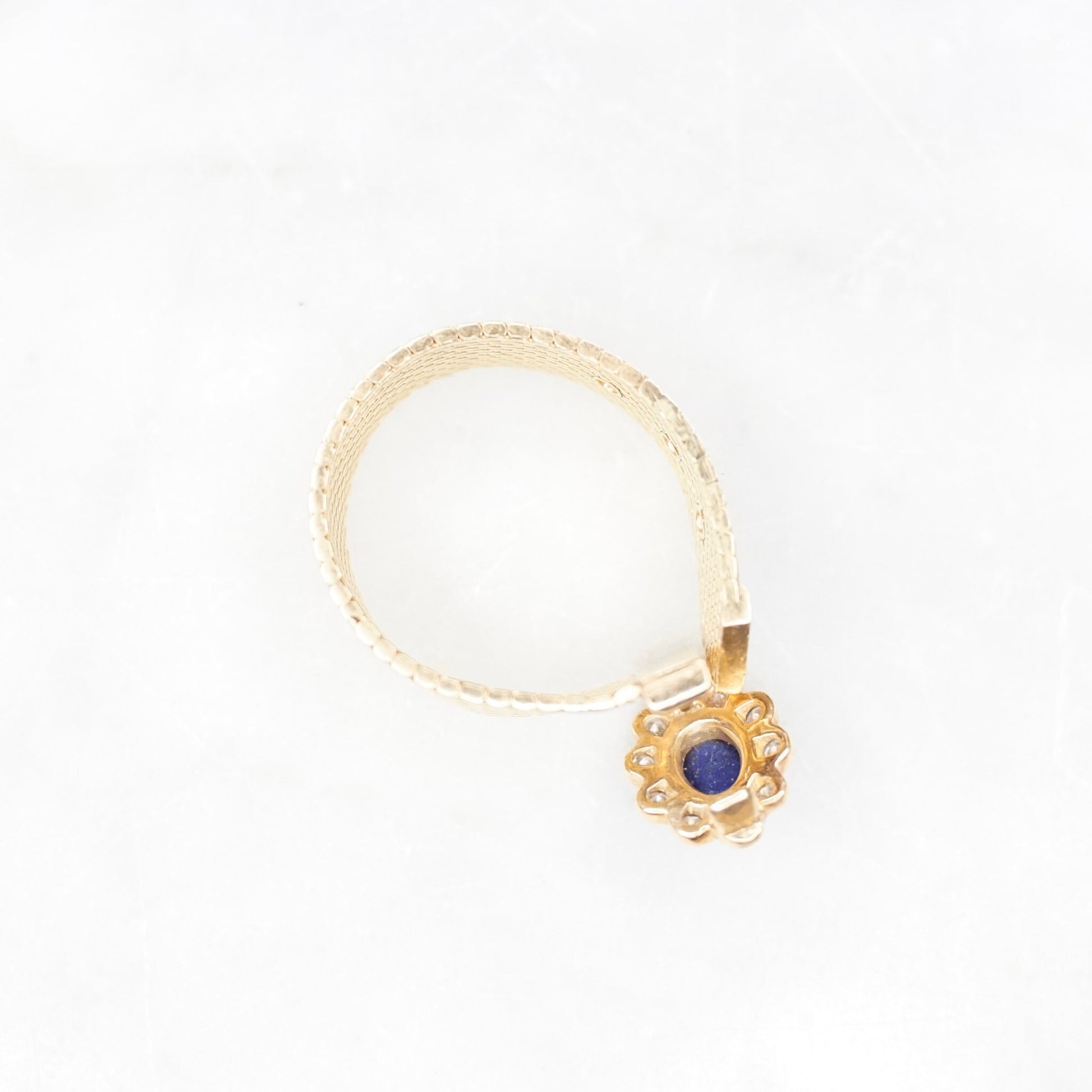 Vintage 14K yellow gold mesh belt buckle ring featuring a lapis lazuli cabochon surrounded by small diamonds set in a flower design. The ring band is an adjustable mesh style. Stamped VCA NY 14K.