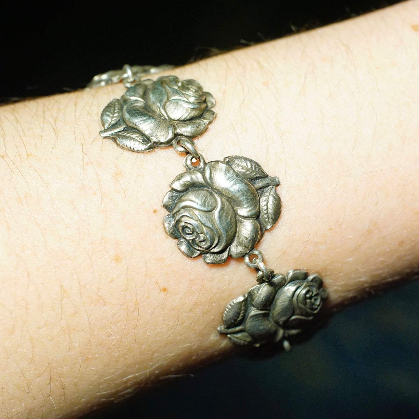 Vintage HMH sterling silver rosebud and Virgin Mary reversible bracelet featuring detailed rose motif links connected to a central medallion depicting the religious figure on one side, crafted in 925 silver for a unique piece of religious jewelry.