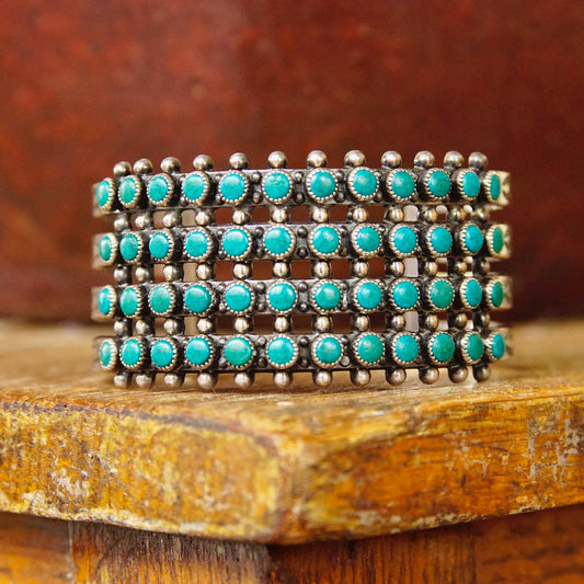Vintage Zuni turquoise and silver cuff bracelet featuring 48 snake eye turquoise stones set in a hammered silver cutout design, Native American old pawn jewelry.