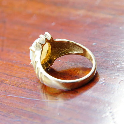 Vintage 14K yellow gold cocktail ring with a beautiful opal center stone accented by diamonds, size 6 1/4 US, photographed on a rustic wooden surface.